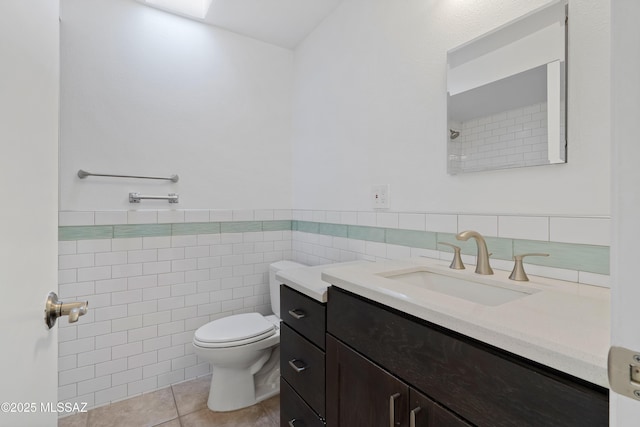 bathroom featuring tile patterned flooring, vanity, tile walls, and toilet