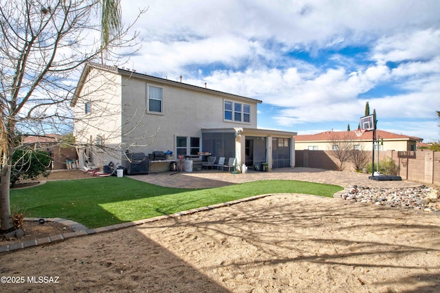 rear view of house featuring a patio, a sunroom, and a yard