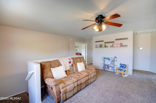 living room featuring ceiling fan, carpet, and a textured ceiling