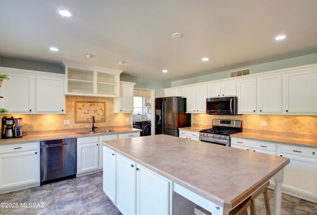 kitchen with sink, a center island, tasteful backsplash, black appliances, and white cabinets