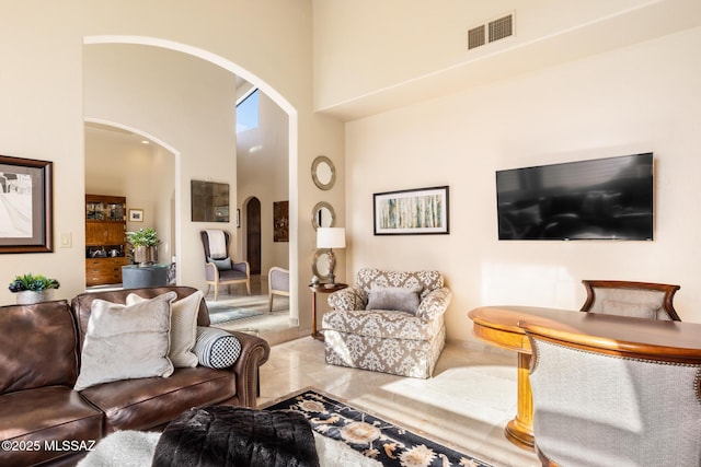 living room with tile patterned floors and a high ceiling