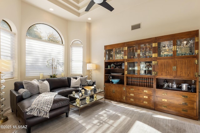 living room featuring ceiling fan and a high ceiling