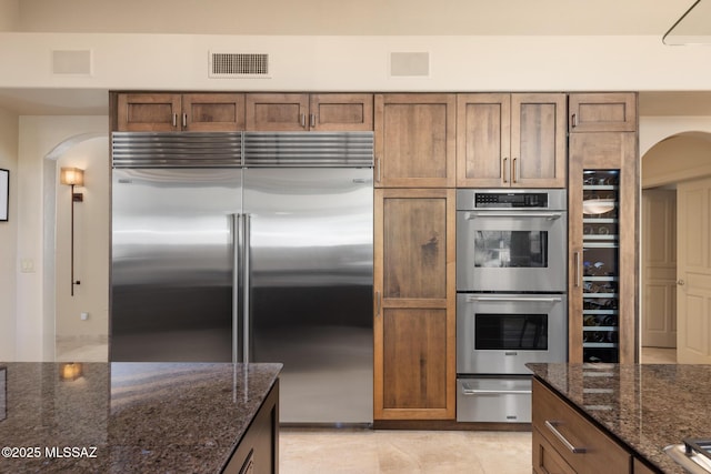 kitchen featuring dark stone countertops and appliances with stainless steel finishes