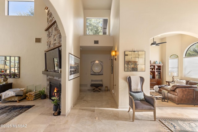 foyer entrance with a towering ceiling and ceiling fan