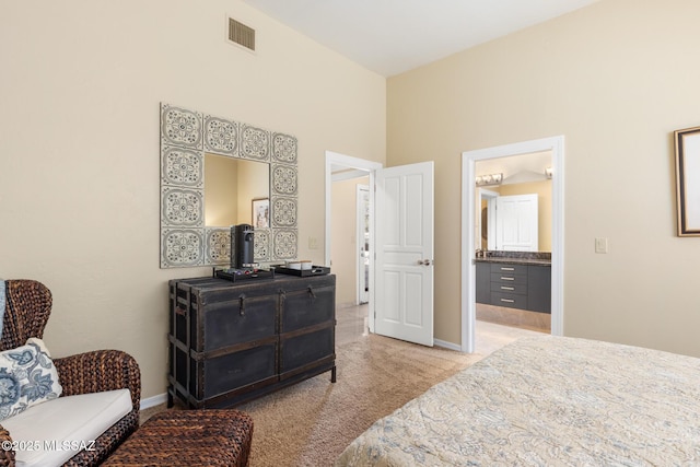 carpeted bedroom with ensuite bath and a towering ceiling