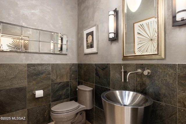 bathroom with tile walls and toilet