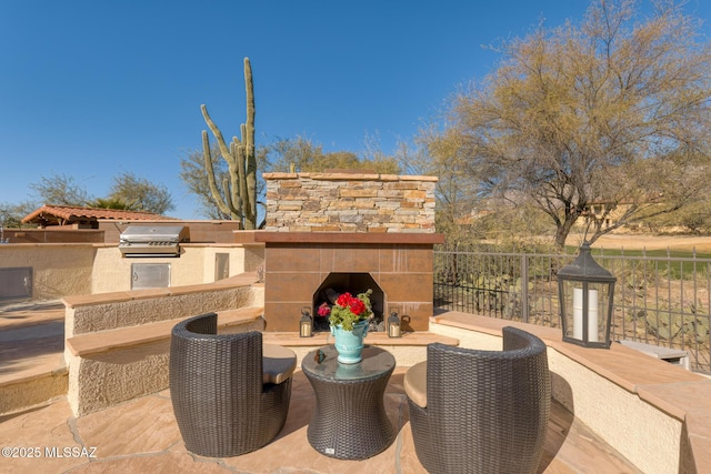 view of patio with exterior fireplace, grilling area, and exterior kitchen