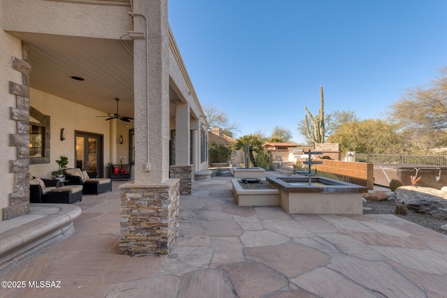 view of patio / terrace with ceiling fan and an outdoor fire pit