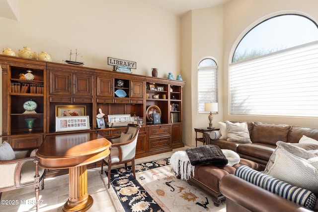 sitting room featuring built in desk and a high ceiling