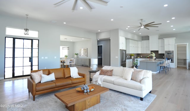 living room with ceiling fan and light hardwood / wood-style flooring