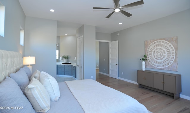 bedroom with ceiling fan, connected bathroom, and light hardwood / wood-style flooring