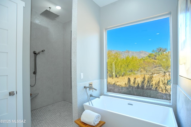 bathroom featuring a mountain view, independent shower and bath, and tile walls