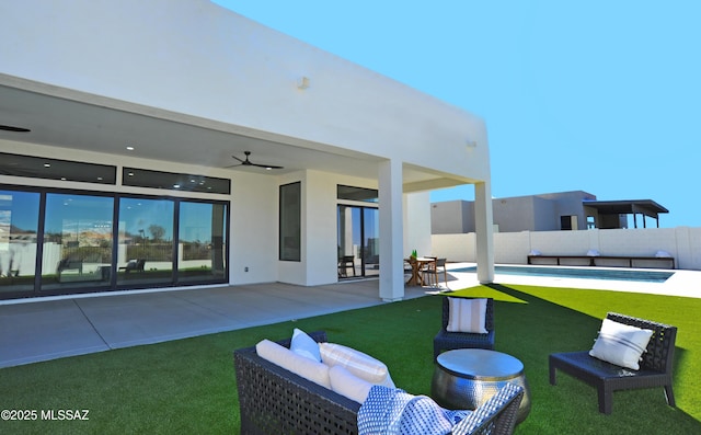 rear view of house featuring ceiling fan, a patio area, and a swimming pool