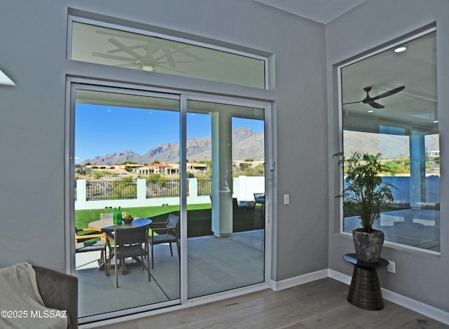 entryway with a mountain view, hardwood / wood-style floors, and ceiling fan