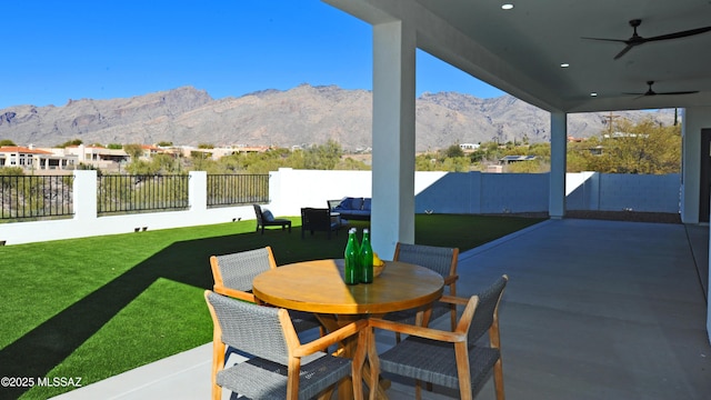 view of patio / terrace featuring ceiling fan and a mountain view