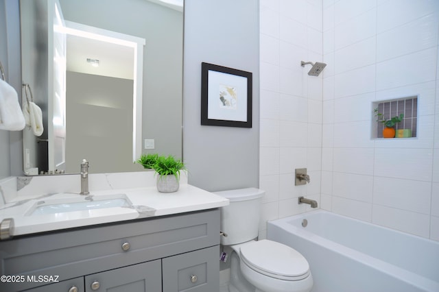 full bathroom featuring vanity, toilet, and tiled shower / bath combo