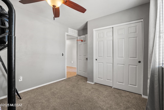 unfurnished bedroom featuring ceiling fan, a closet, and carpet