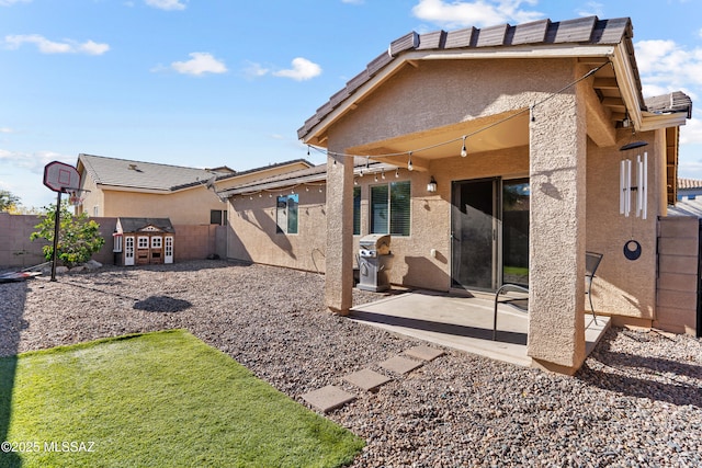 rear view of house with a patio area and a shed