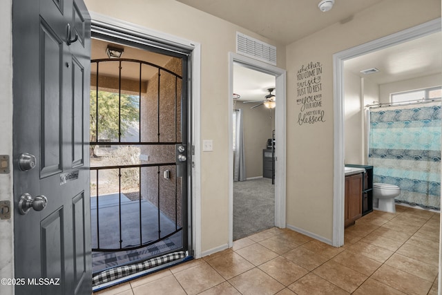 tiled foyer with ceiling fan