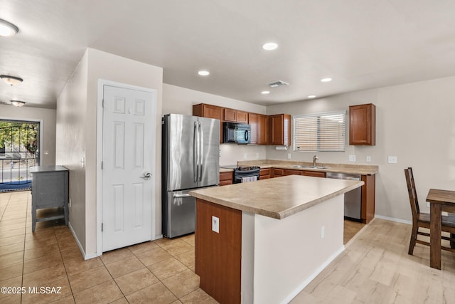 kitchen featuring light tile patterned floors, sink, a kitchen island, and black appliances