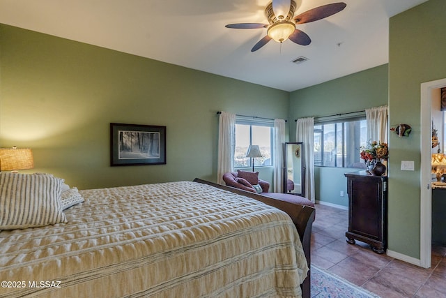 bedroom with a ceiling fan, visible vents, baseboards, and light tile patterned floors