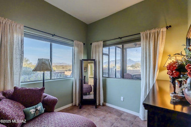 bedroom featuring light tile patterned floors, a mountain view, and baseboards