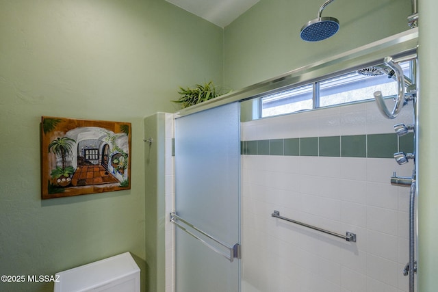 bathroom featuring a stall shower and toilet