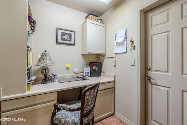 home office with built in study area and baseboards