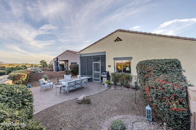 patio terrace at dusk featuring a sunroom, fence, and grilling area