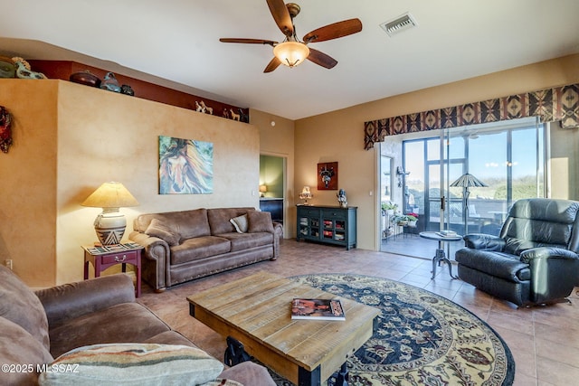 tiled living area with visible vents and a ceiling fan