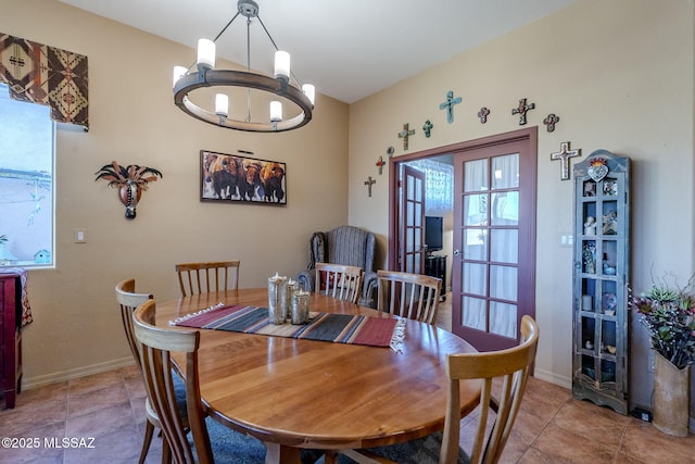 dining space featuring baseboards, light tile patterned floors, and an inviting chandelier