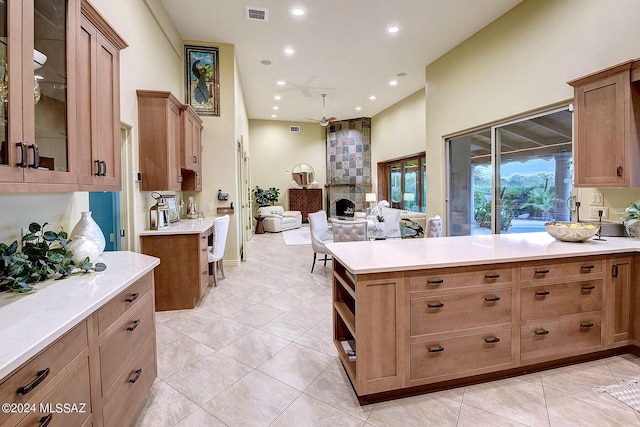 kitchen with ceiling fan, light tile patterned floors, and a fireplace