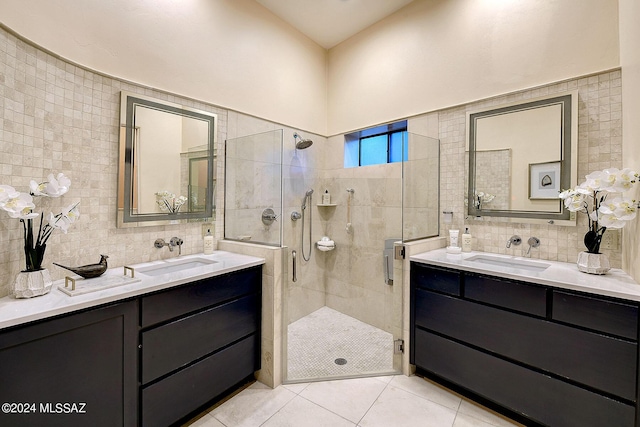 bathroom with tasteful backsplash, walk in shower, vanity, tile walls, and tile patterned flooring