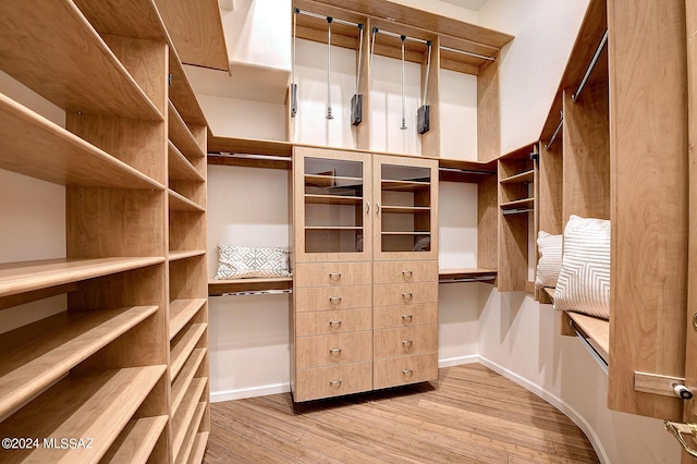 spacious closet with light hardwood / wood-style floors