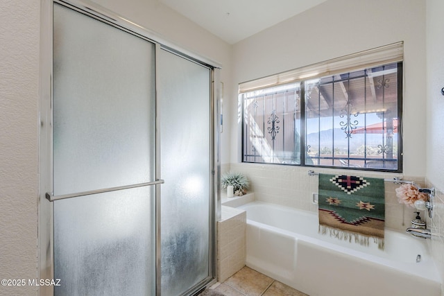 bathroom with tile patterned flooring, a bath, and a shower with door