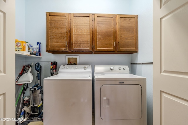 washroom with cabinet space and washer and clothes dryer