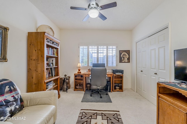 office area featuring a ceiling fan, a textured ceiling, and light colored carpet