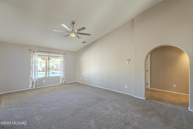 carpeted empty room with ceiling fan and lofted ceiling