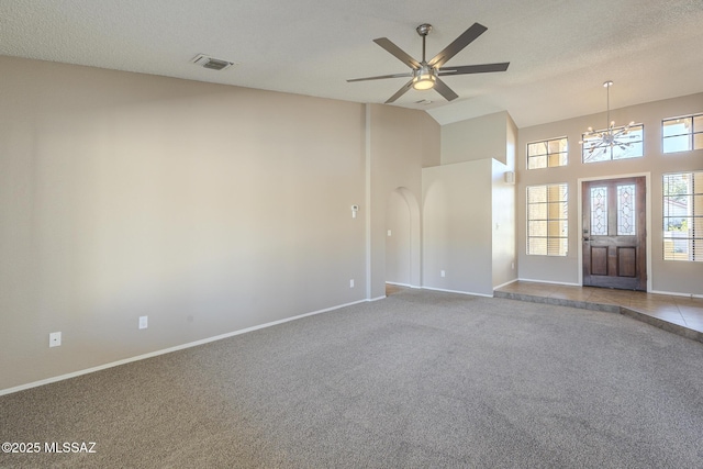 carpeted spare room featuring ceiling fan with notable chandelier and a textured ceiling