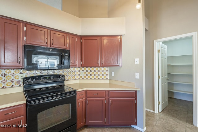 kitchen featuring black appliances, light tile patterned floors, backsplash, and a high ceiling