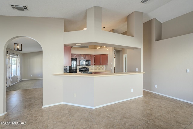 kitchen with black appliances, backsplash, a towering ceiling, and kitchen peninsula