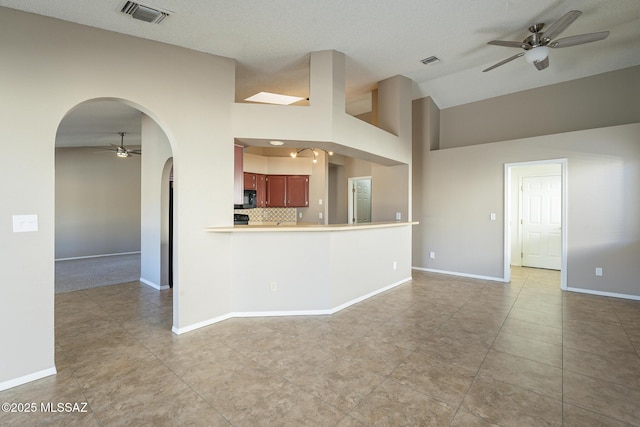 kitchen with a textured ceiling, ceiling fan, kitchen peninsula, and tasteful backsplash