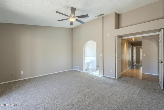 spare room featuring a textured ceiling, ceiling fan, and carpet flooring