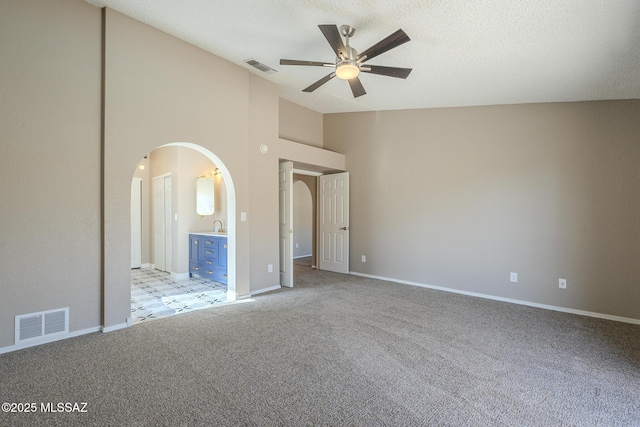 interior space featuring ceiling fan, high vaulted ceiling, sink, a textured ceiling, and light carpet