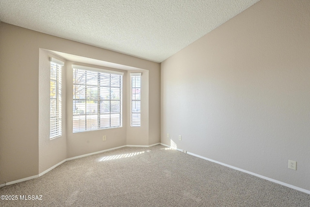 carpeted spare room with a textured ceiling