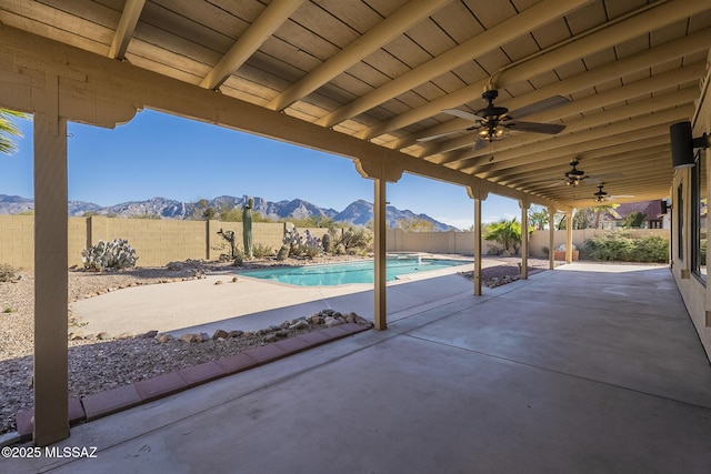 view of patio / terrace featuring a mountain view, a fenced in pool, and ceiling fan