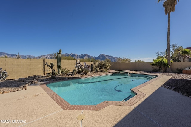 view of swimming pool with a mountain view, an in ground hot tub, and a patio