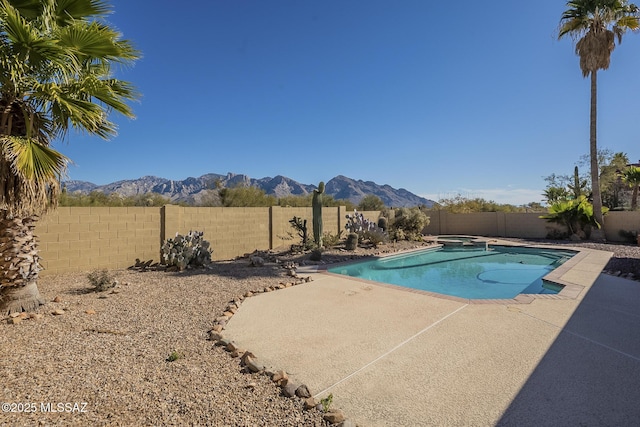 view of swimming pool featuring a patio area and a mountain view