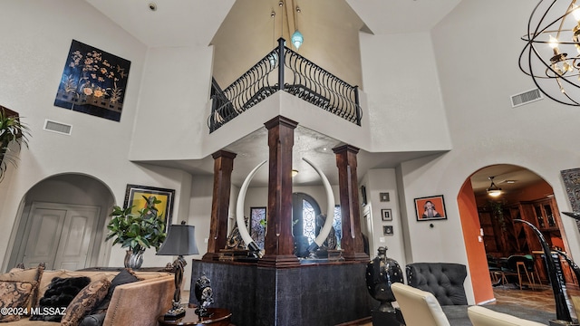 interior space with ornate columns, a towering ceiling, and a chandelier