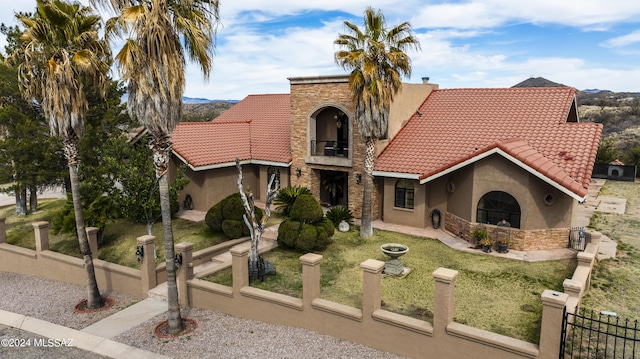 mediterranean / spanish home with a balcony and a front lawn